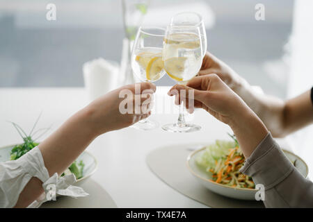 Close-up de trois femmes toasting verres d'eau dans un restaurant. Banque D'Images