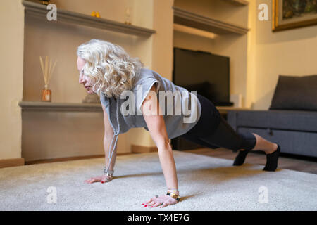 Young woman doing Yoga de l'exercice dans la salle de séjour Banque D'Images