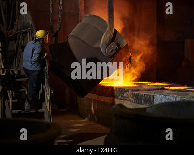 L'industrie, le cuivre liquide est versé dans le moule, le contrôle ouvrier Banque D'Images