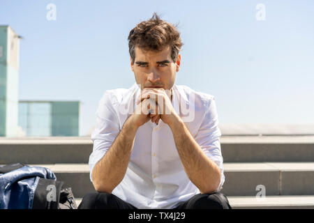 Portrait of serious businessman sitting on stairs ayant une pause Banque D'Images