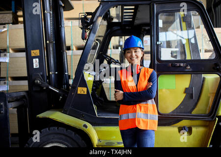 Portrait of female worker au chariot élévateur en usine Banque D'Images