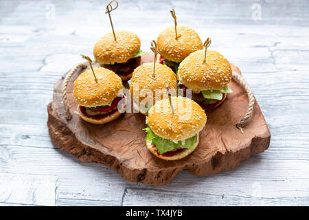 Mini-Burger avec la viande hachée, salade, tomate et concombre sur plateau en bois Banque D'Images