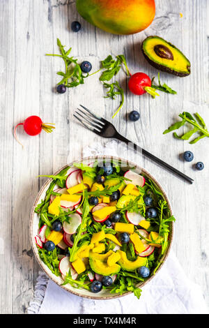 Bol de salade de roquette à la mangue, avocat, radis rouges et les bleuets Banque D'Images