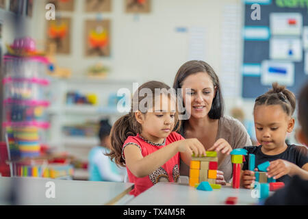 Enseignante préscolaire jouer avec les filles de la maternelle Banque D'Images