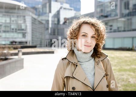 Portrait de jeune femme en cheveux bouclés portant imperméable beige Pull col roulé et Banque D'Images