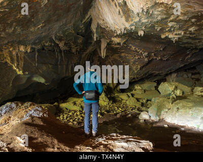 Espagne, Pays basque, Euskadi, senior man affichage des roches dans la grotte de Baltzola Banque D'Images