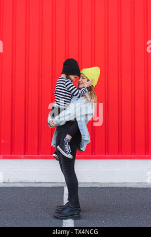 Teenage girl holding jeune sœur sur ses bras Banque D'Images