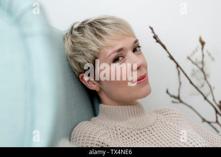 Portrait de femme assise dans un fauteuil à la maison Banque D'Images