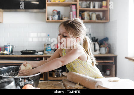 Petite fille rouler la pâte dans la cuisine Banque D'Images