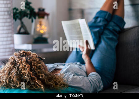 Femme couchée sur la table à la maison Lire un livre Banque D'Images