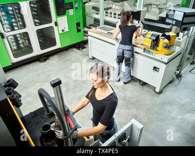 Jeune femme travaillant sur une machine Banque D'Images