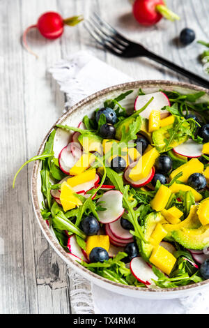 Bol de salade de roquette à la mangue, avocat, radis rouges et les bleuets Banque D'Images