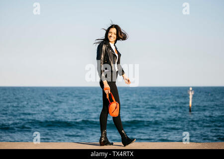 Young woman smiling while looking at camera, marche à l'Harbour Banque D'Images