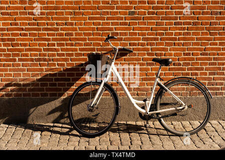 Danemark, copenhague, location appuyé contre un mur de briques à la lumière du soleil Banque D'Images
