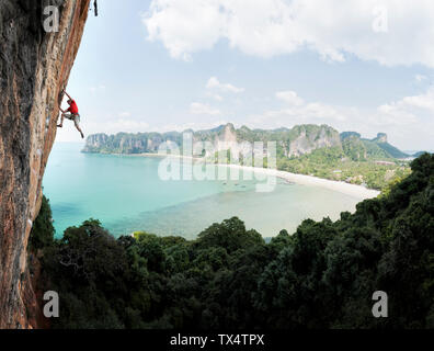 La Thaïlande, Krabi, Thaiwand wall, l'homme de l'escalade dans un mur de pierre au-dessus de la mer Banque D'Images