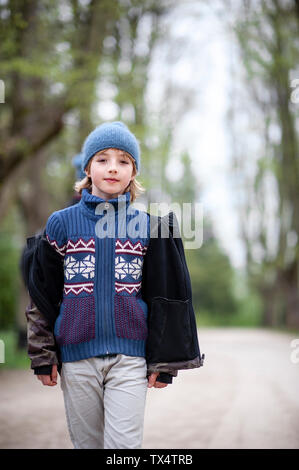 Portrait of young boy wearing hat chandail bleu et dans un parc Banque D'Images