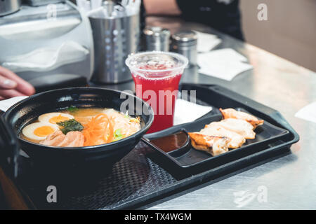 Soupe de Ramen avec des boulettes de porc sur un plateau en plastique dans un fast food japonais cafe. Le concept Asian le déjeuner ou le dîner. Banque D'Images