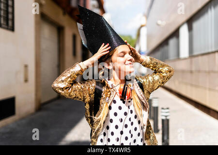 Portrait of smiling girl wearing black crown et golden sequin jacket Banque D'Images