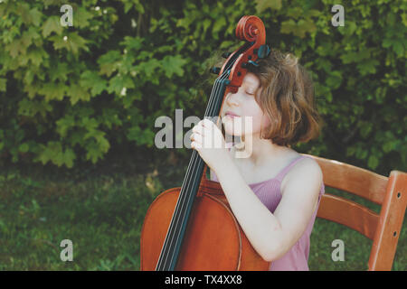 Une jeune fille en faisant une pause au cours de ses exercices de violoncelle Banque D'Images