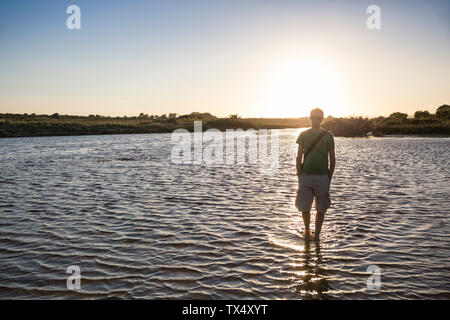 Italie, Sicile, jeune homme à la plage de Eloro au coucher du soleil Banque D'Images