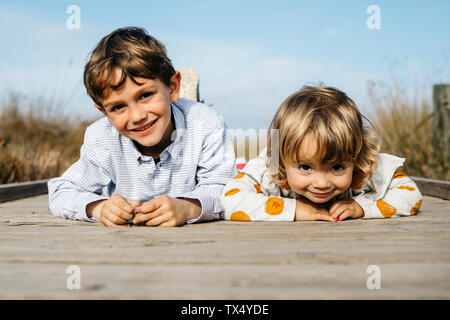 Portrait of smiling boy et sa petite sœur se trouvant côte à côte sur la demande Banque D'Images