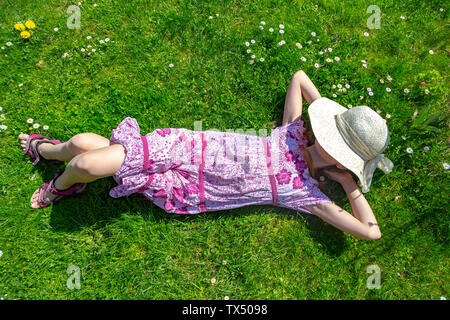 Girl lying on meadow in garden Banque D'Images