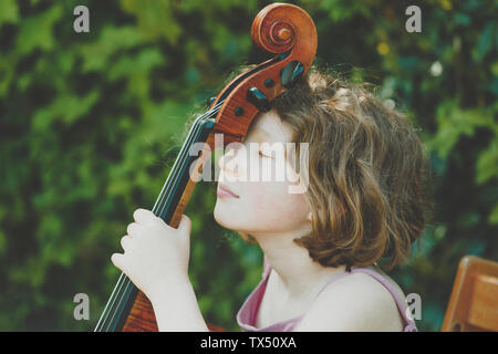 Une jeune fille en faisant une pause au cours de ses exercices de violoncelle Banque D'Images