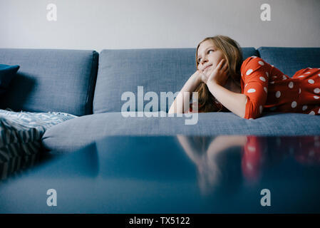 Girl lying on sofa at home Banque D'Images