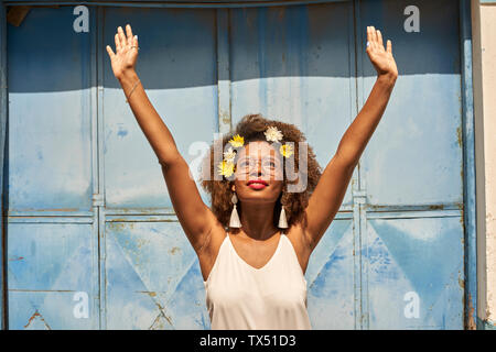 Portrait of happy young woman with red lips portant des lunettes et des fleurs dans les cheveux Banque D'Images