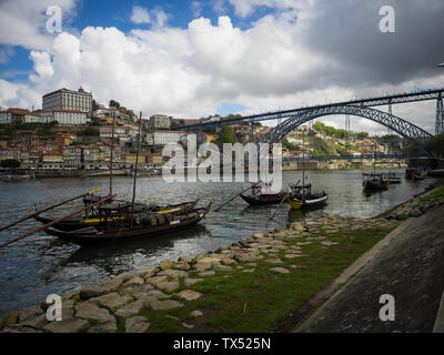 Le vieillissement en fûts de port des bateaux sur le fleuve Douro à Porto, Portugal, à l'horizon du patrimoine mondial derrière eux Banque D'Images