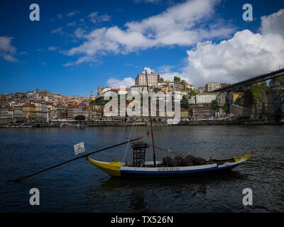 Le vieillissement en fûts de port des bateaux sur le fleuve Douro à Porto, Portugal, à l'horizon du patrimoine mondial derrière eux Banque D'Images