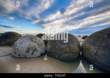 La Nouvelle Zélande, la Côte d'Otago, Moeraki Boulders sur Koekohe Plage avec ciel dramatique Banque D'Images