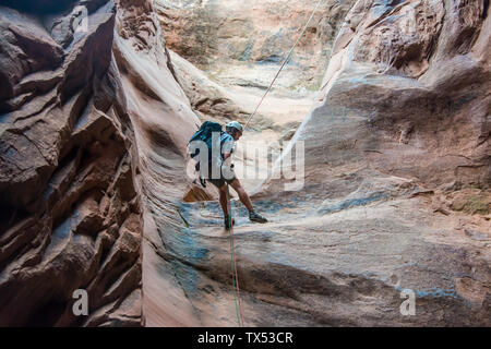 USA, Utah, Moab, Canyonering, des activités de l'homme vers le bas dans la fente canyon Banque D'Images