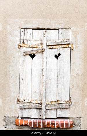 Old weathered volets gris en forme de cœur avec windows dans les trous de mur antique Banque D'Images