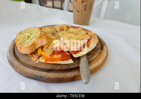 Fromage à pizza mince et croustillante avec du saumon, du jambon, du bacon sur plateau en bois Banque D'Images