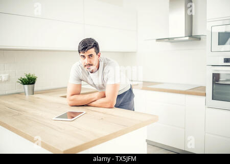 Jeune homme dans la maison cuisine avec tablette. Banque D'Images