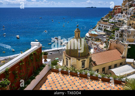 Majestic sunny cityscape de Positano hill-ville sur la côte amalfitaine en Italie. Il y a beaucoup de maisons multicolores avec l'église Santa Maria Assunta sur le blu Banque D'Images