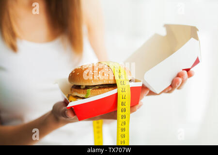 Régime alimentaire et Fast Food Concept. L'excès de Femme Debout sur Weighin Banque D'Images