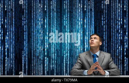 Homme avec les mains pliées à la vers le haut. Young businessman sitting at desk. L'entreprise porte programmateur costume et cravate sur le cyberespace numérique avec l'arrière-plan Banque D'Images