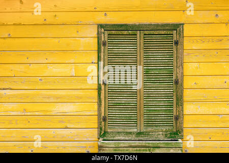 Vieux mur de bois vert jaune avec fenêtre.Maison décoration Banque D'Images