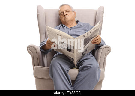 Un homme âgé avec un journal de dormir dans un fauteuil isolé sur fond blanc Banque D'Images