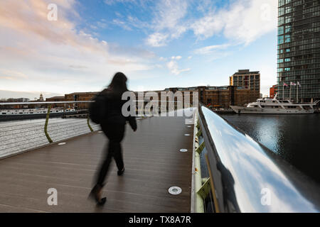 Les gens d'affaires et de navetteurs traversant le quai Nord passerelle de Canary Wharf à West India Quay. Docklands, Londres, Angleterre, Royaume-Uni. Banque D'Images