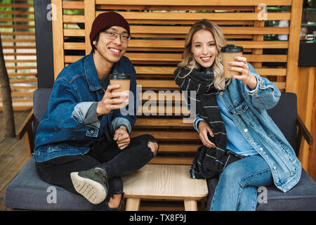 Multhiethnic sititng Smiling couple au café en plein air, de boire du café, à discuter Banque D'Images