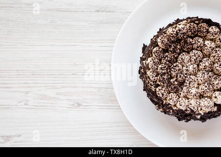 Gâteau tiramisu fait maison sur une plaque blanche sur une table en bois blanc, vue du dessus. Copier l'espace. Banque D'Images