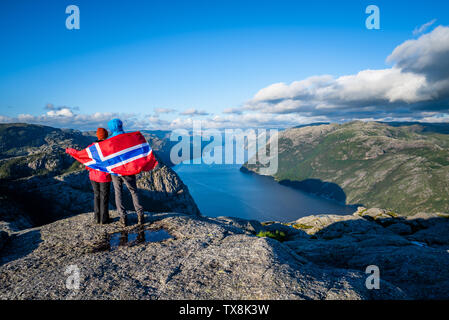 Vue sur le fjord Lysefjord du Preikestolen. Couple de touristes avec le pavillon de la Norvège Banque D'Images