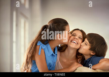 Portrait de femme qui reçoit un baiser sur chaque joue de son fils et sa fille. Banque D'Images