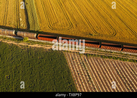 Le transport ferroviaire de marchandises, vue aérienne du train passant sur le chemin de fer par les champs cultivés dans la campagne Banque D'Images