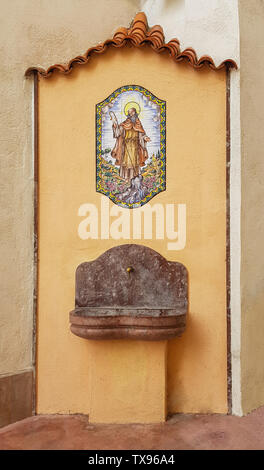 Fontaine d'eau potable avec lavabo en marbre et peinture sur la façade. La vieille ville de Tarragone, Espagne. Banque D'Images