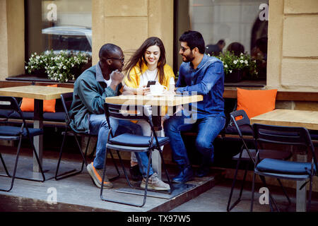 Trois amis heureux multiculturelle ayant un temps de café au café en plein air Banque D'Images