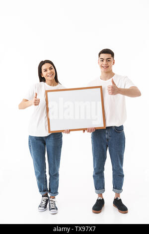 Portrait d'un jeune beau couple isolés sur fond blanc, vierge présentant, Thumbs up Banque D'Images